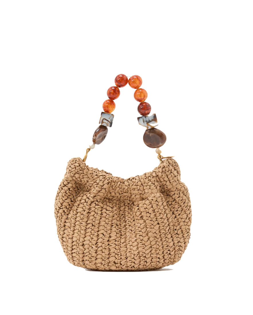 Woven raffia bag with beaded handle on a white background